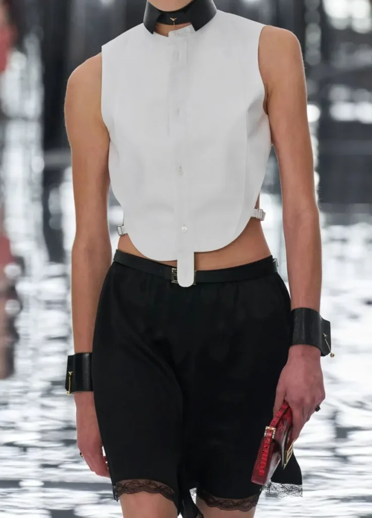 Fendi Spring 2027 Look 1
— white bib shirt, lace-trimmed bloomer shorts, leather collar and cuffs