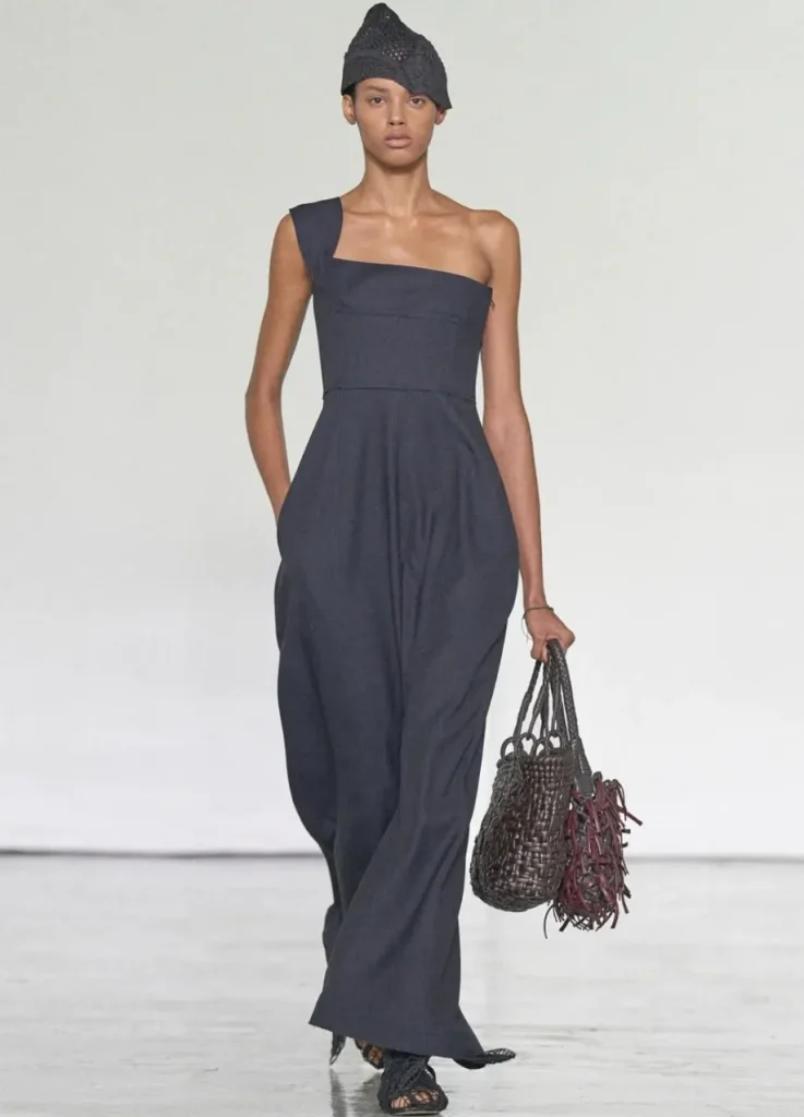 Bottega Veneta Spring 2027 Look 50,
dark navy one-shoulder long dress with crochet cap and woven leather bag