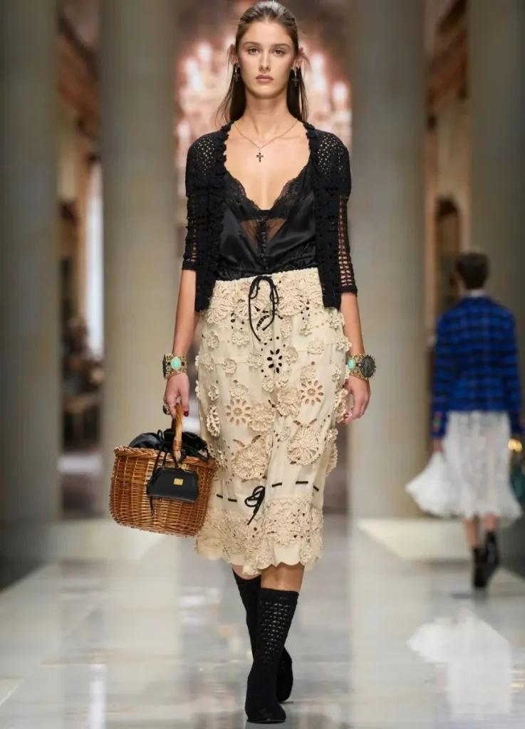 Dolce & Gabbana Spring 2027 Look 53
— black cardigan over camisole, cream embellished skirt, basket bag