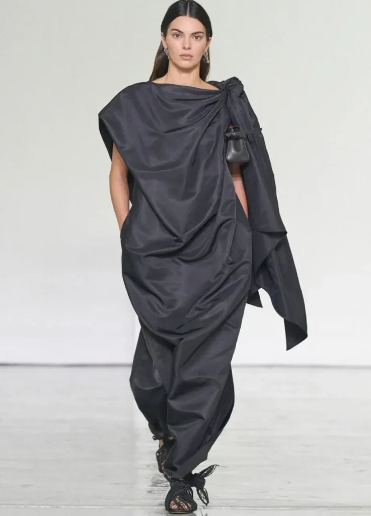 Bottega Veneta Spring 2027 Look 62
Kendall Jenner closing Bottega Veneta Spring 2027 in a black draped gown
with a small leather bag at the shoulder